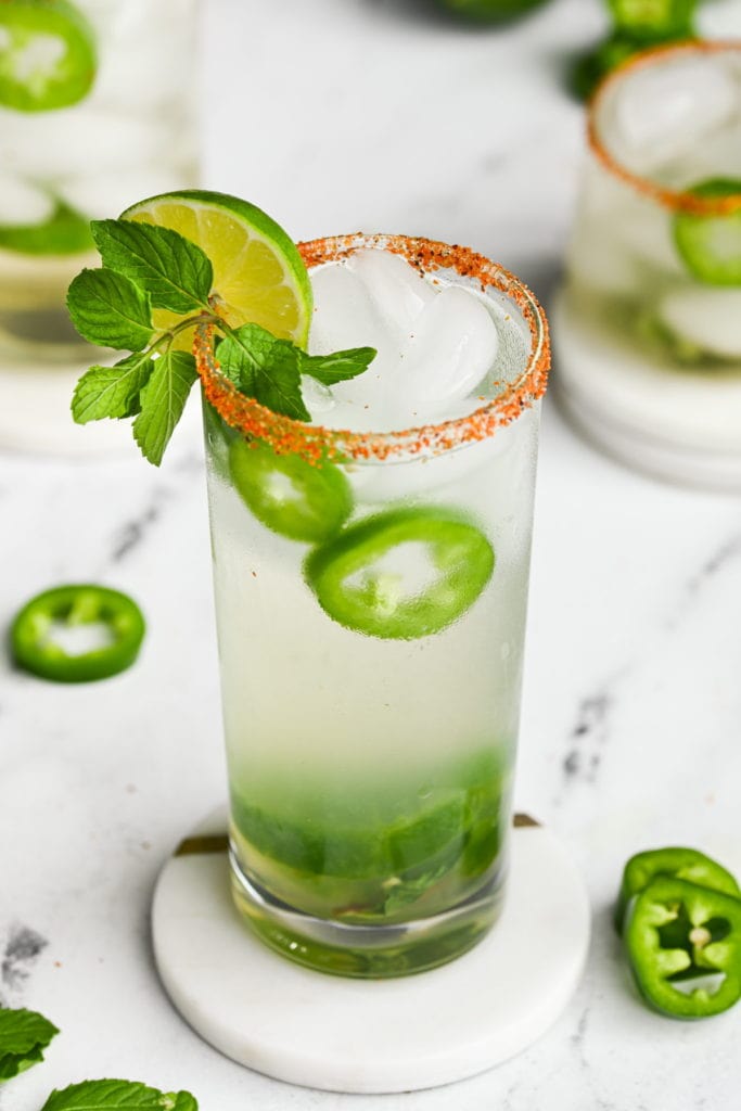 spicy mojito in a highball glass with tajin rim and green garnish