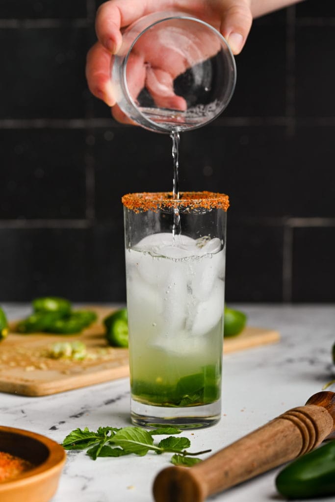 adding club soda to mojito with jalapeno to give it bubbles