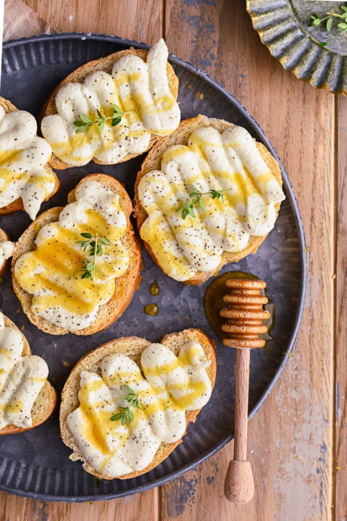 whipped ricotta crostini close up with honey dipper