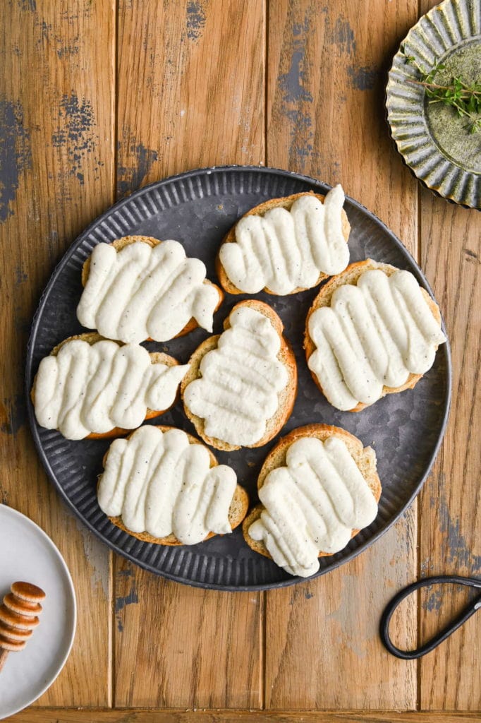 whipped ricotta piped on to toasted bread with piping bag