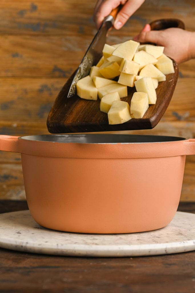 adding potato chunks to boiling water