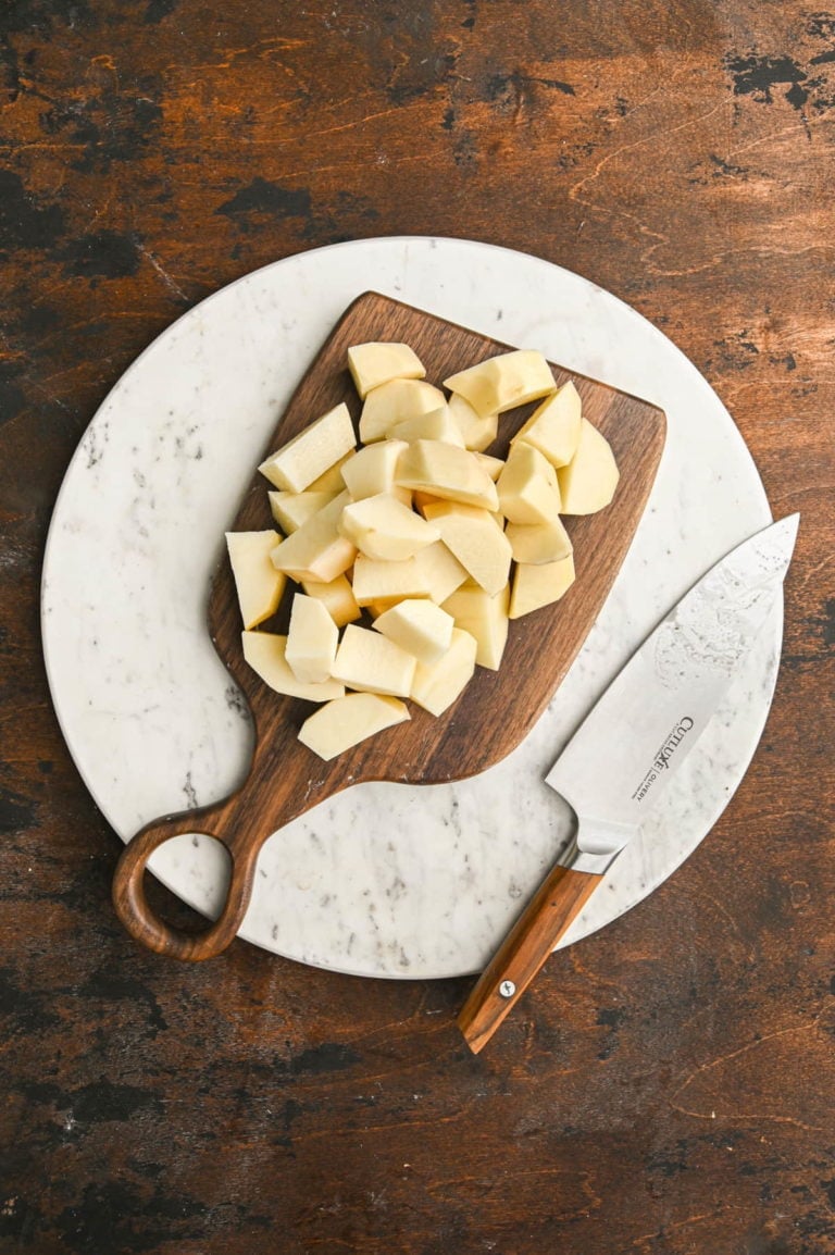 chopping potatoes into small chunks so they will cook faster in boiling water
