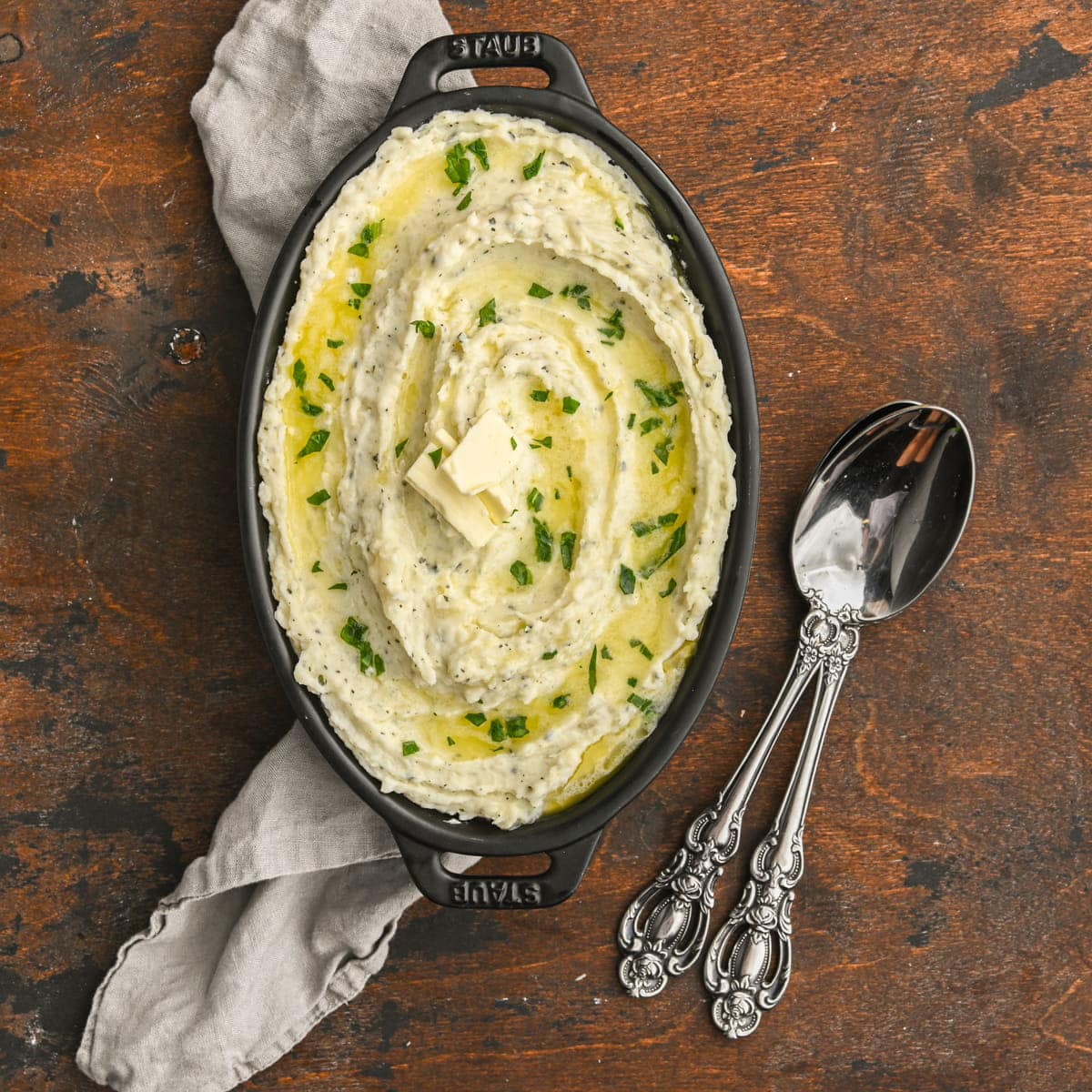 Creamy Boursin Mashed Potatoes garnished with melted butter and chopped basil