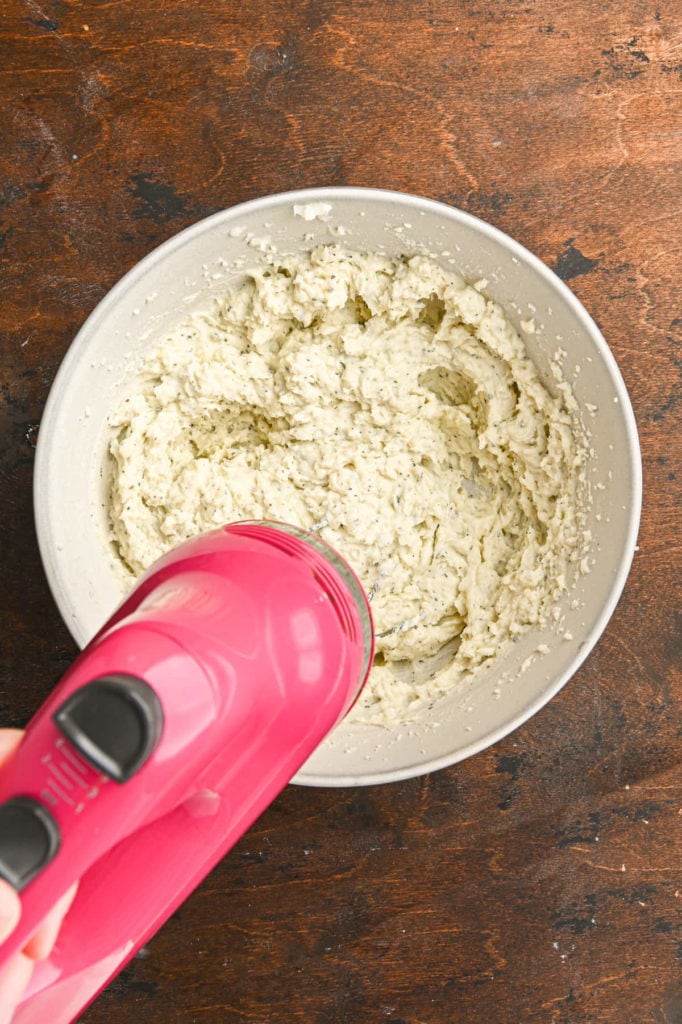 using a hand mixer to whip boursin mashed potatoes