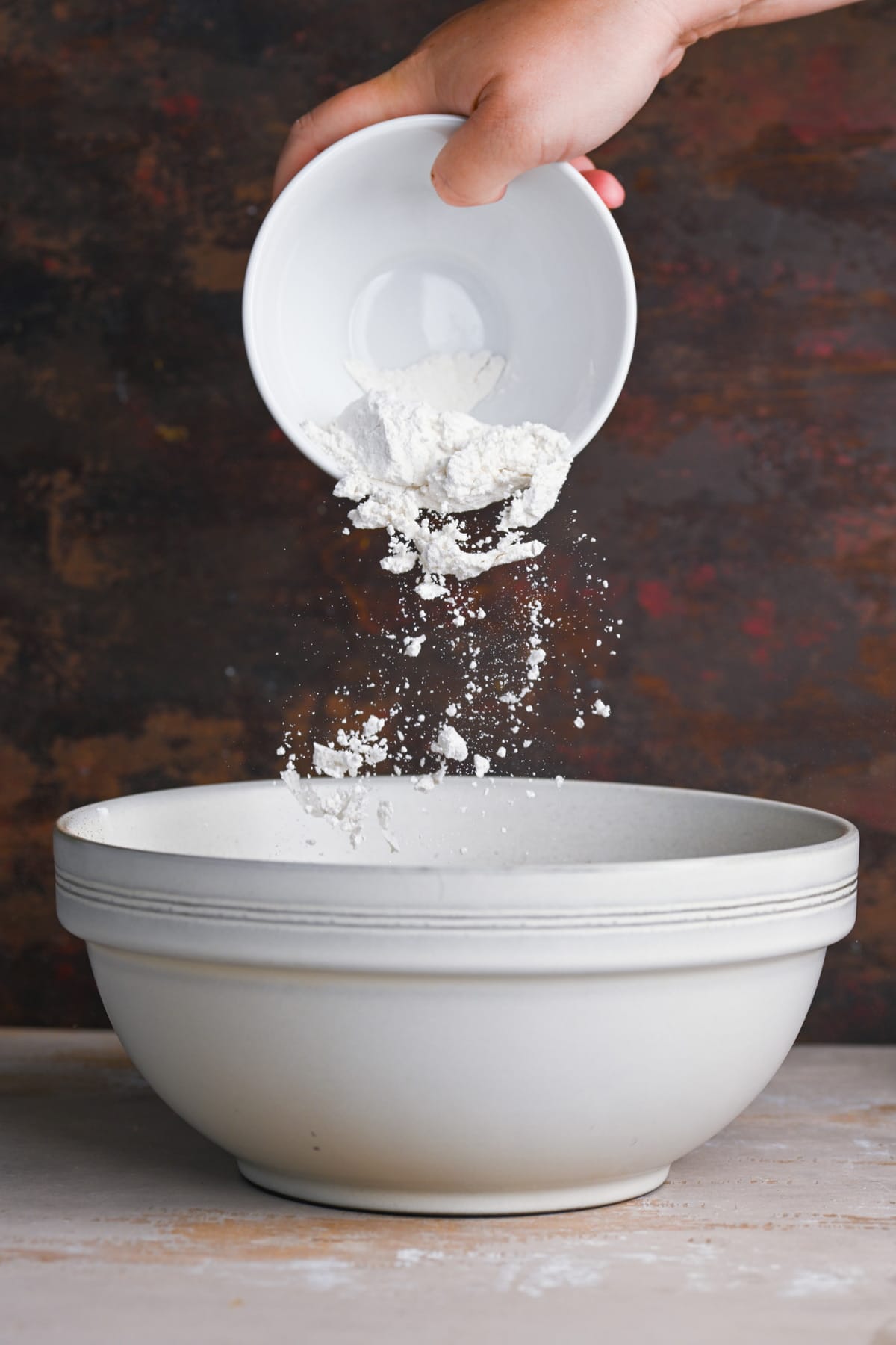 Adding flour to condensed milk brownie batter.