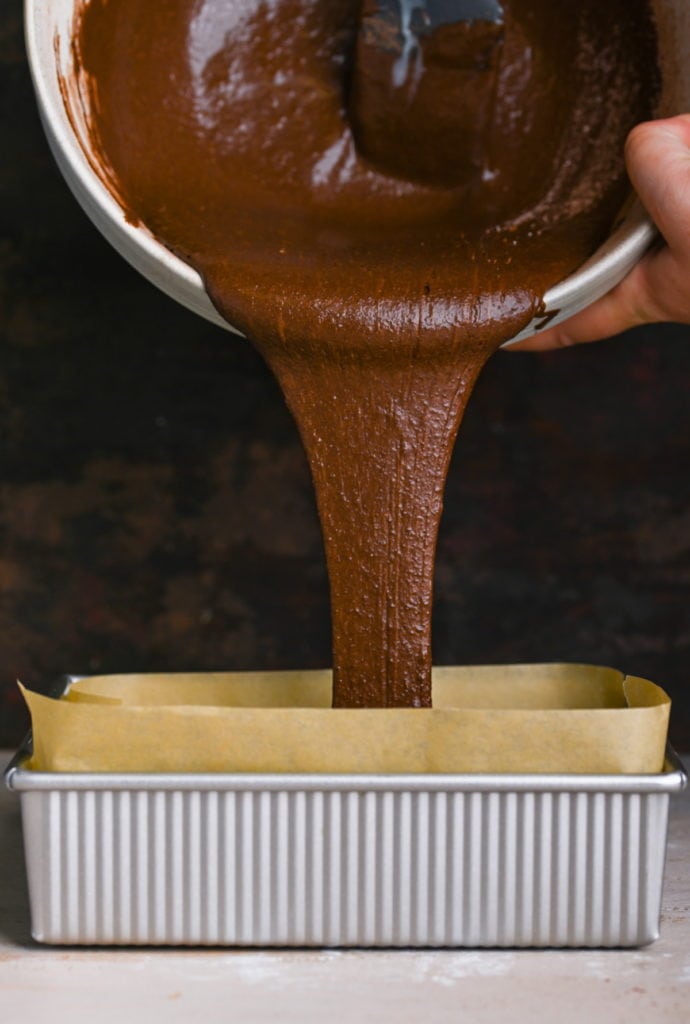 transferring brownie batter to lined baking pan