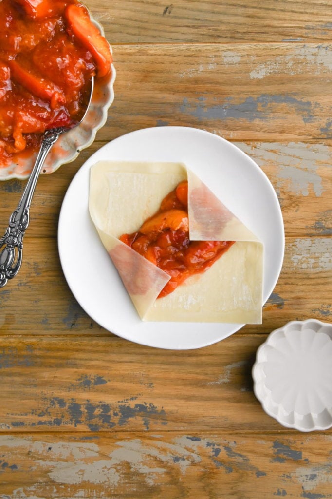 Folding up sides of egg roll wrapper.