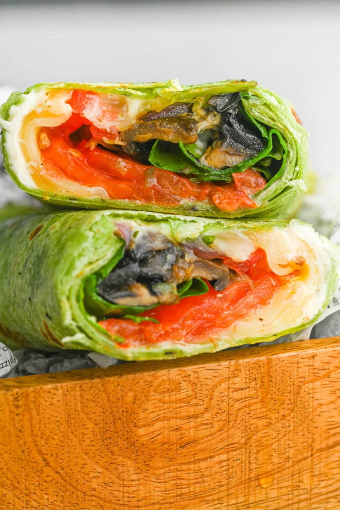 close up of portobello mushroom wrap sliced in half to reveal whats inside