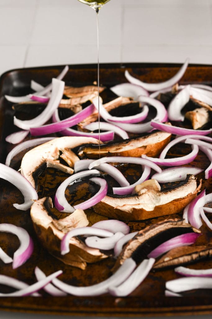 adding oil, soy sauce, salt, pepper, and maple syrup to sliced portobello mushrooms and onion