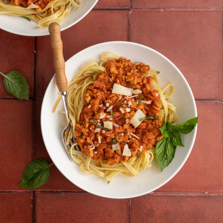 overhead shot of vegan tempeh bolognese served over fettuccine