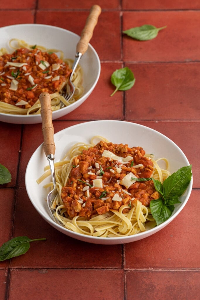 2 plates of Tempeh Bolognese served over Fettuccine with basil