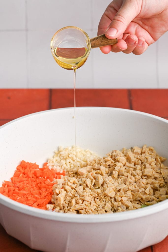 adding olive oil to pan with tempeh, carrot, celery, shallot, and garlic to brown the tempeh