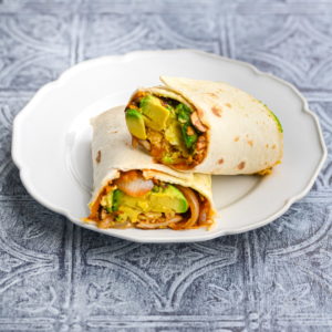 vegetarian breakfast burrito cut in half with one half resting on the other