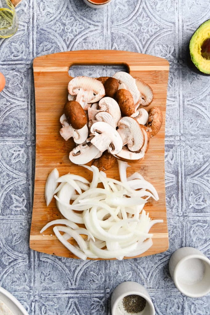 slices onions and mushrooms on a cutting board