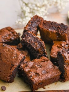 sliced condensed milk brownies all sitting on parchment paper at different angles