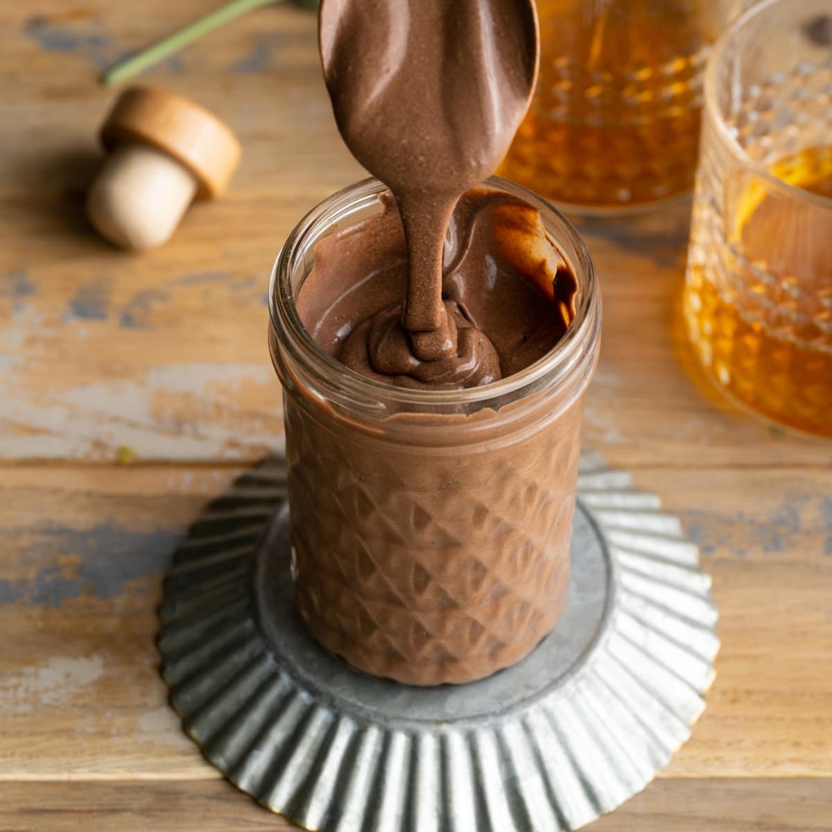 bourbon chocolate sauce dripping off a spoon into a jar