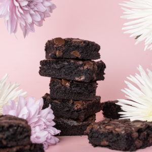 stack of dairy free brownies surrounded by flowers