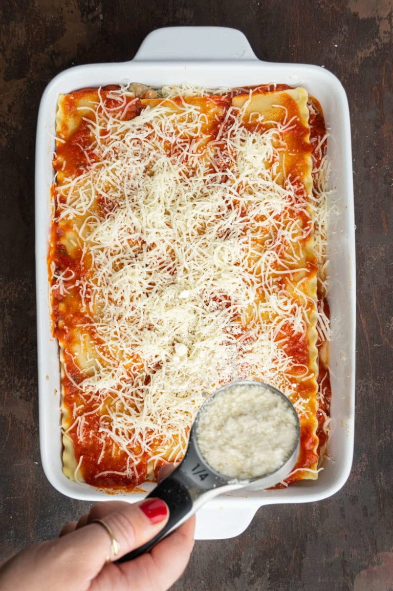 adding layer of parmesan cheese to top of meatless lasagna