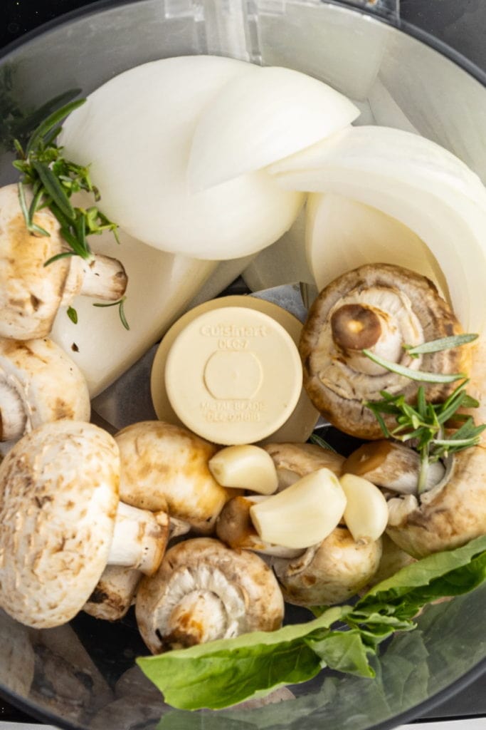 Using a food processor to break down onion, mushrooms, garlic and herbs to replace meat in sauce.
