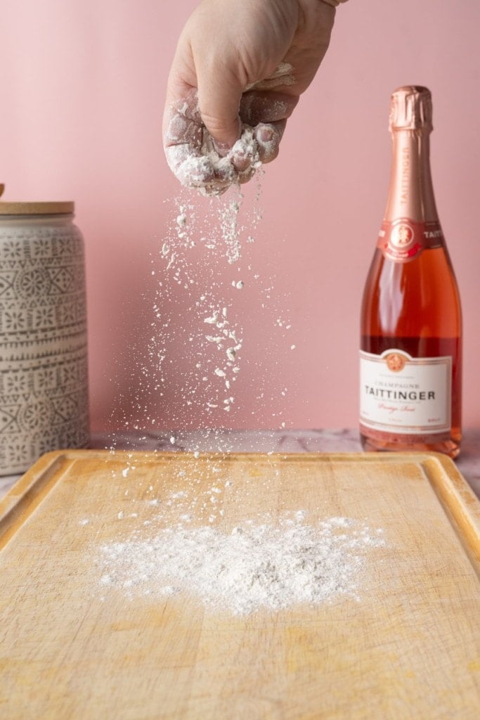 Flouring surface of a large cutting board to roll pizza dough out on.