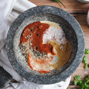 Overhead Image of chili and taco seasoning in a mortar with the pestle on the table