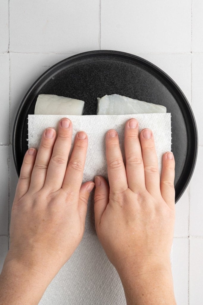 using paper towel to dry off excess moisture from fresh halibut