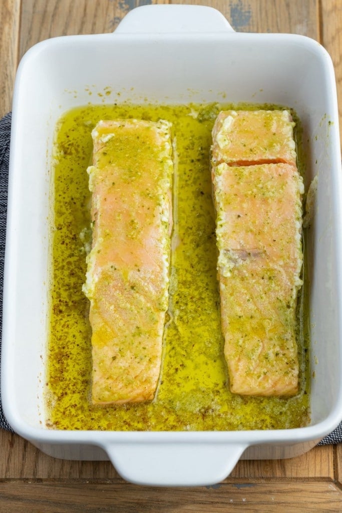 flipping pesto butter salmon to finish baking in the oven