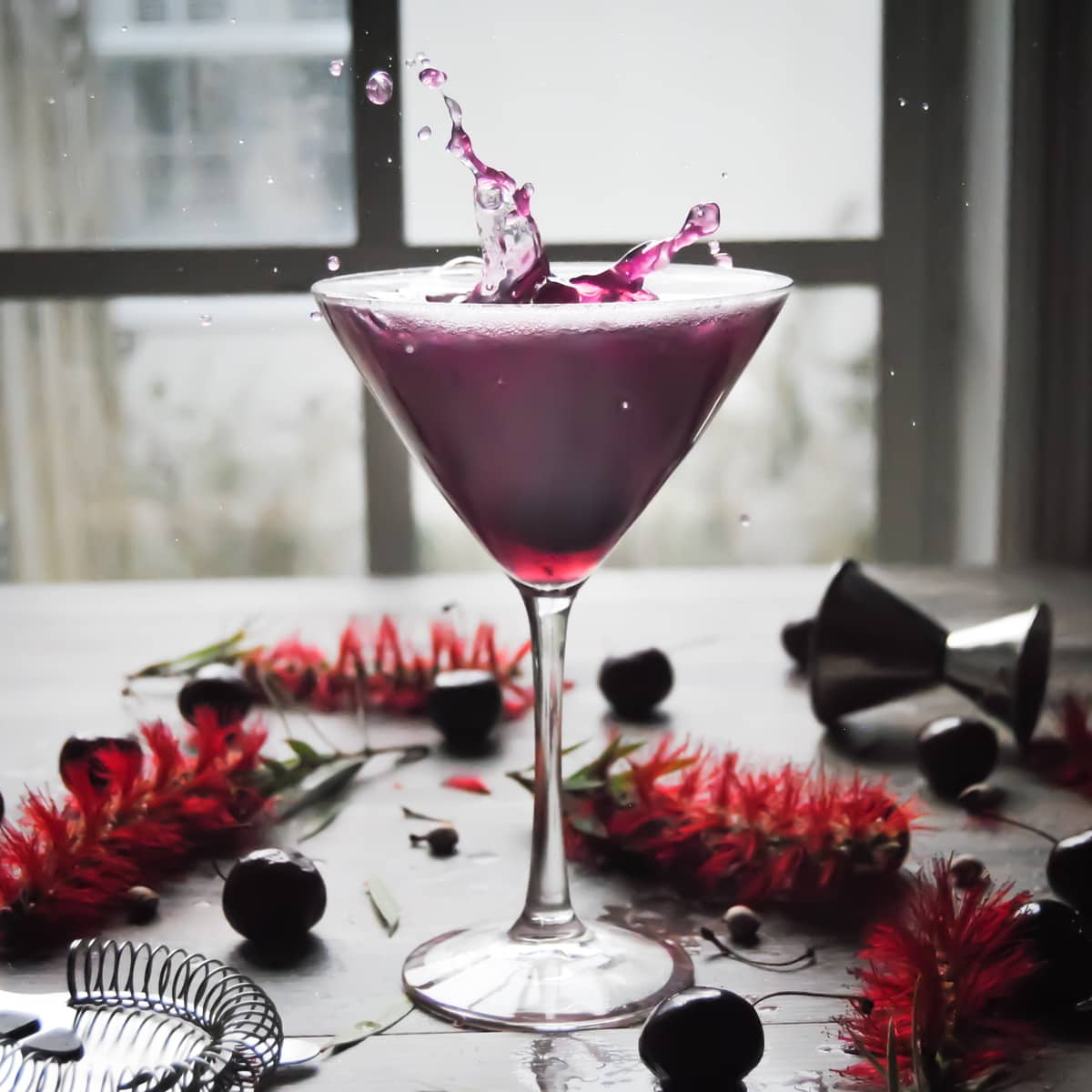 a martini glass with sweet cherry martini cocktail, garnished with cherries
