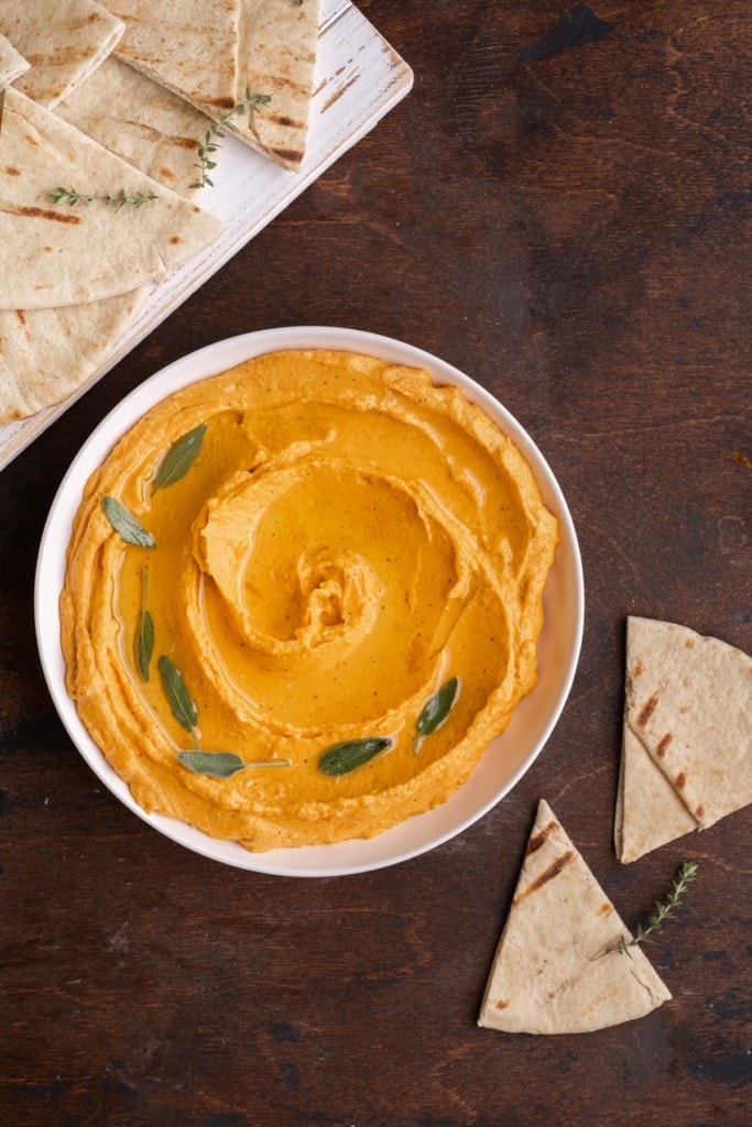 overhead shot of sweet potato hummus in a bowl served with pita