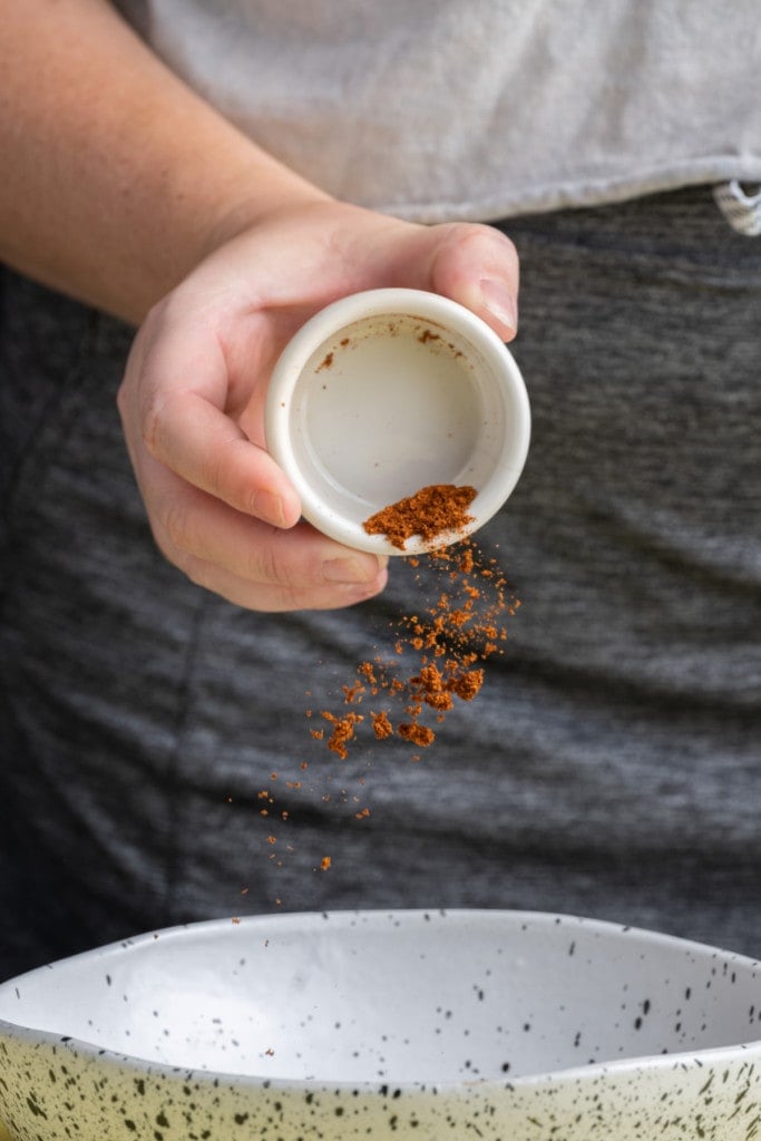 Adding paprika to shallow bowl to make Blackening Seasoning