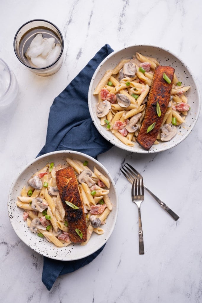 Overhead shot of two servings of blackened salmon pasta