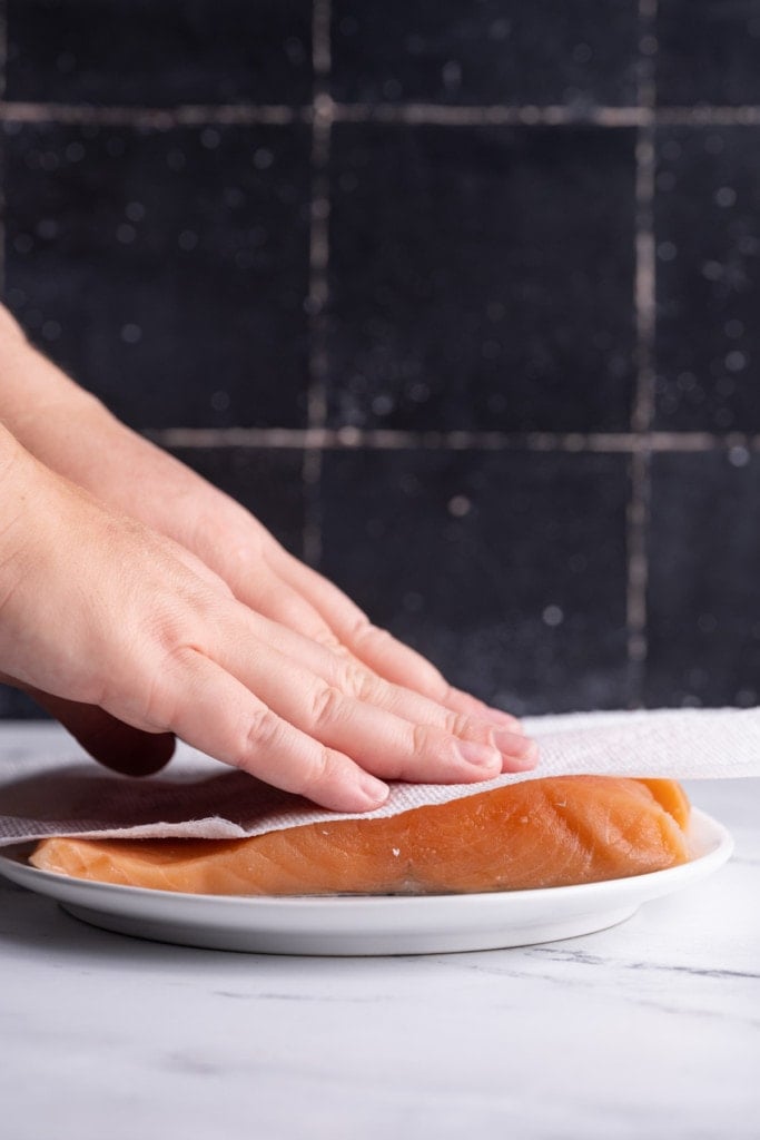 Patting dry salmon with paper towel