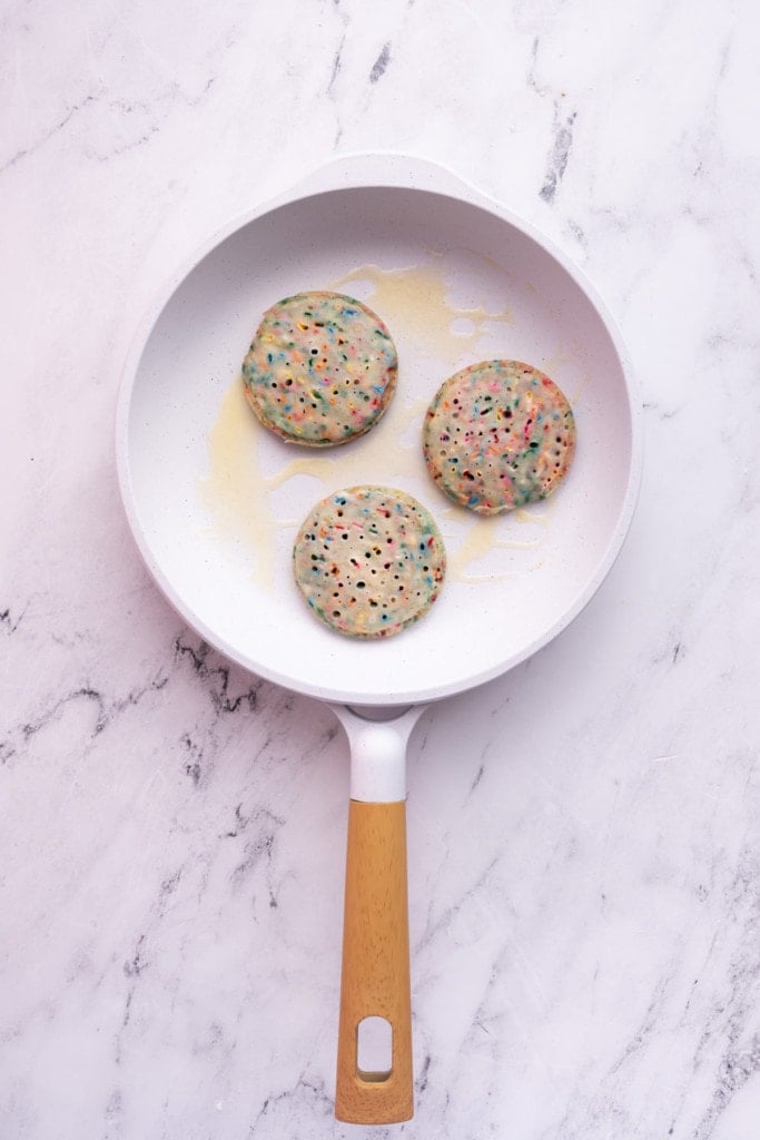 Frying Funfetti Pancakes in butter in a white pan