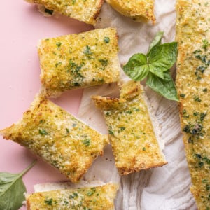 Pesto Butter Garlic Bread on pink background