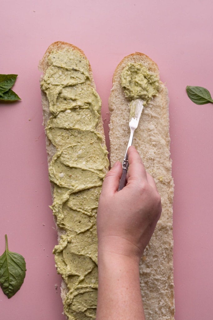 Spreading Pesto Butter on French bread