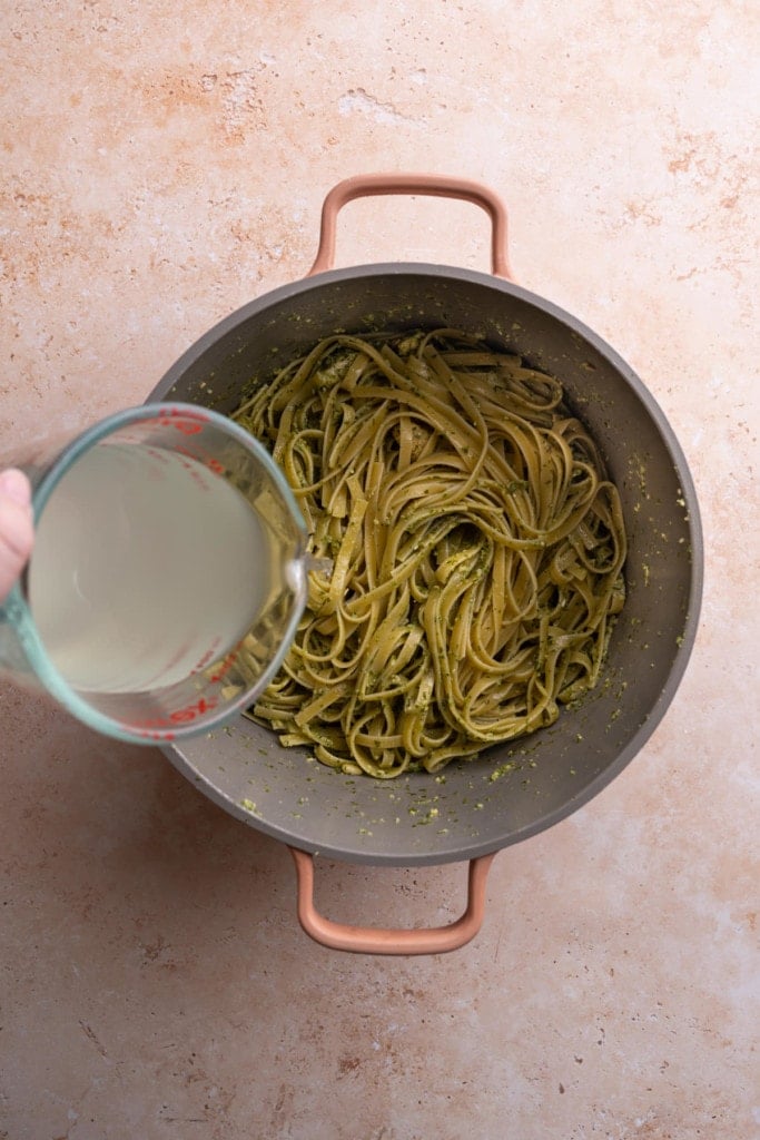 Adding pasta water back to pasta to loosen it