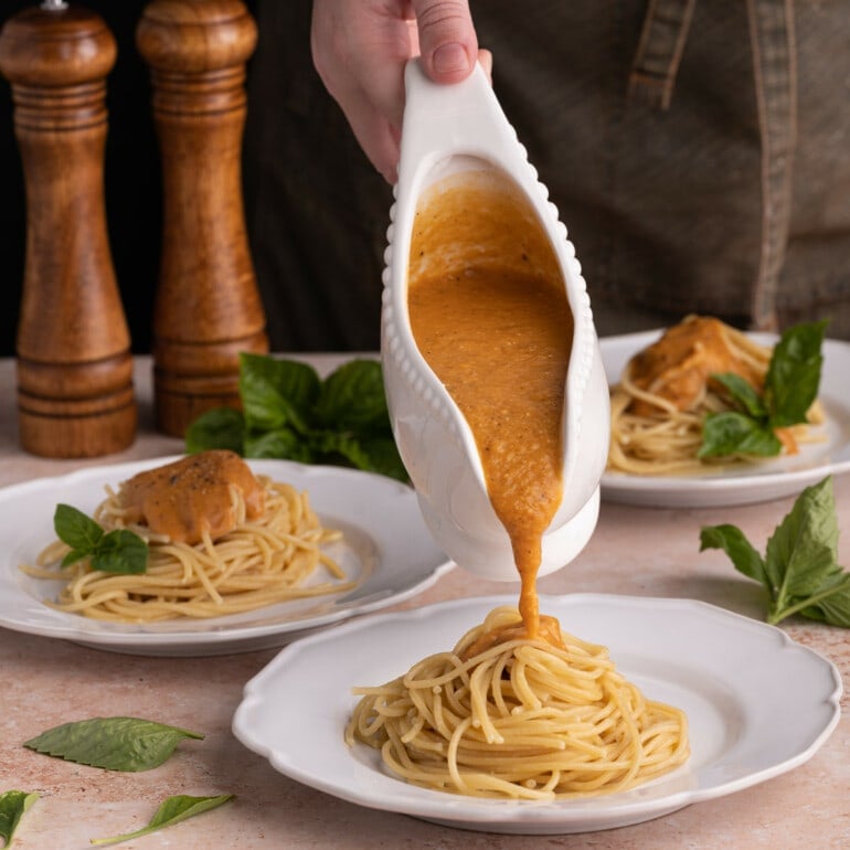 Pouring Sweet Potato Pasta Sauce onto spaghetti