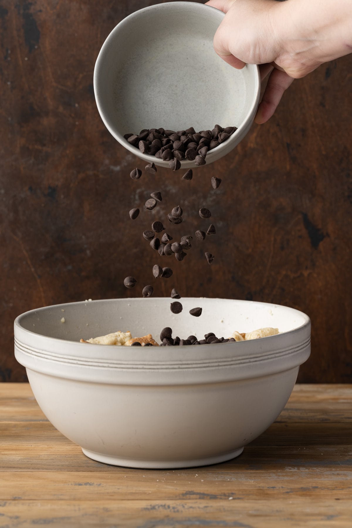 Adding chocolate chips to bread pudding.