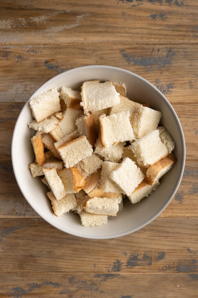 Cubing stale bread to make bread pudding