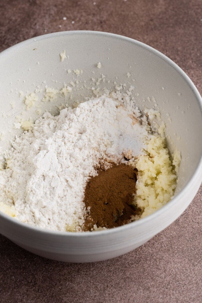 Adding cooled flour, vanilla extract, milk, cinnamon, and salt to Snickerdoodle cookie dough