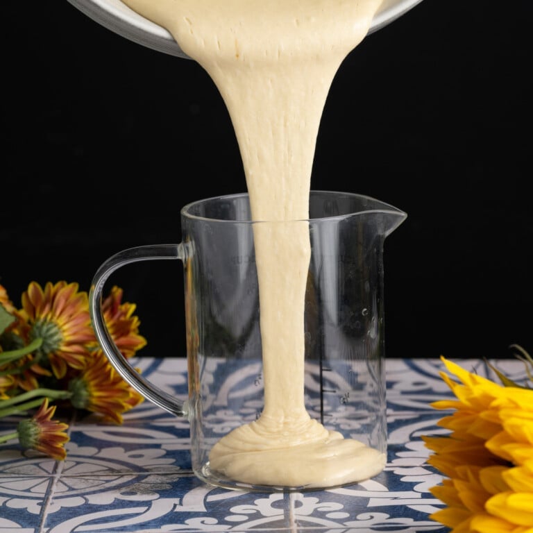 adding dairy-free pancake batter to a measuring cup to more easily pour into pan