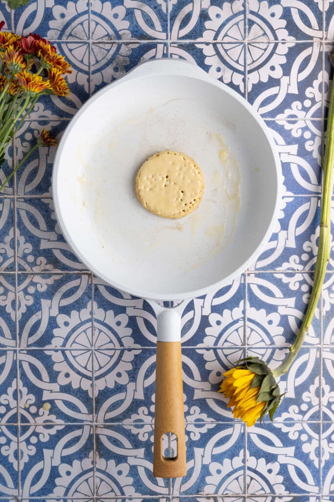 Dairy-free pancake frying in a pan ready to flip