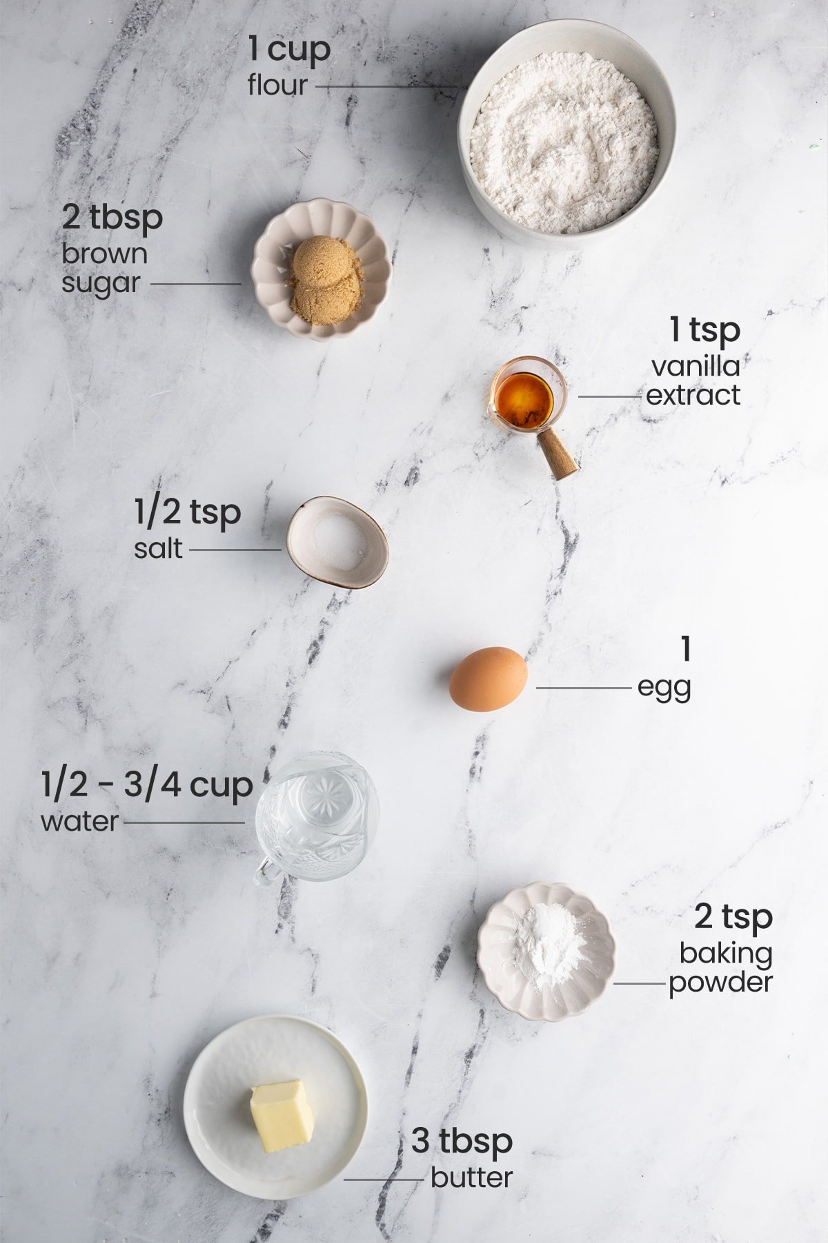 ingredients for no milk pancakes - flour, brown sugar, vanilla extract, salt, egg, baking powder, water, butter