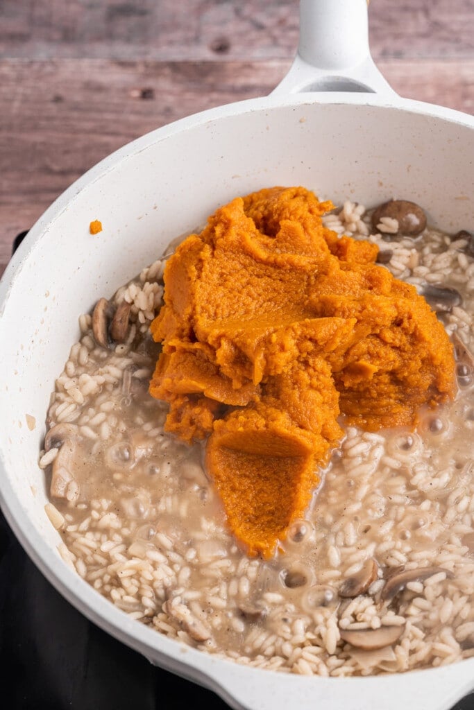 Adding pumpkin puree to mushroom risotto