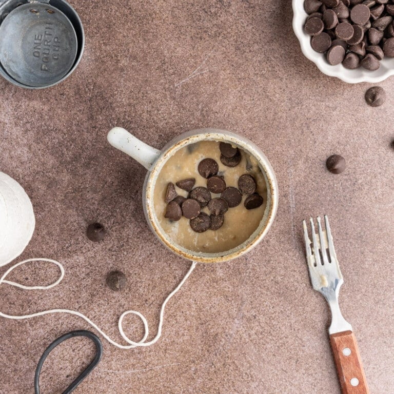 Adding chocolate chips to mug cake batter