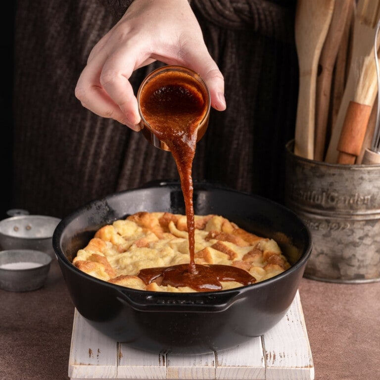 Pouring caramel sauce over bread pudding