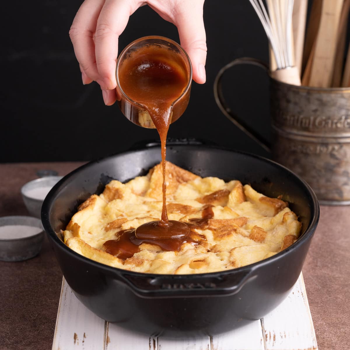 Pouring sauce over Bread Pudding with Caramel Sauce