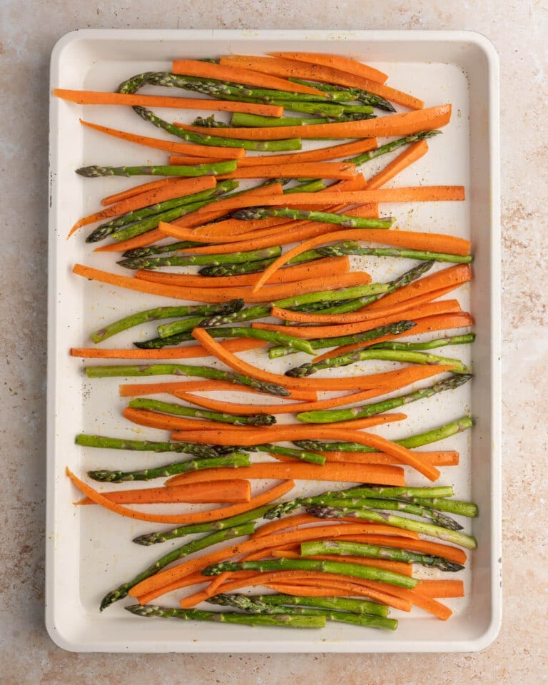 Carrots and asparagus on a baking sheet ready to roast