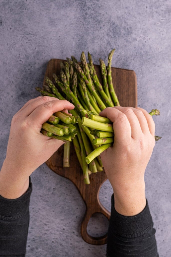 Snapping asparagus to break off woody ends