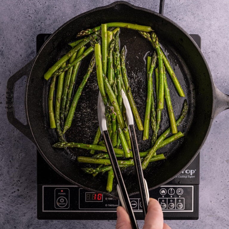 tossing asparagus in oil and seasonings